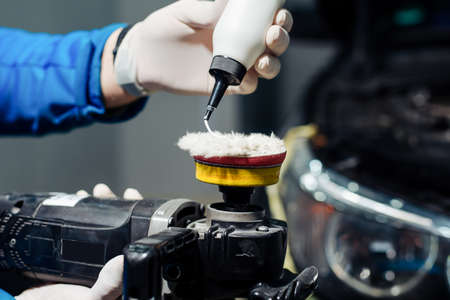 Car headlights cleaning with power buffer machine at car serviceの写真素材