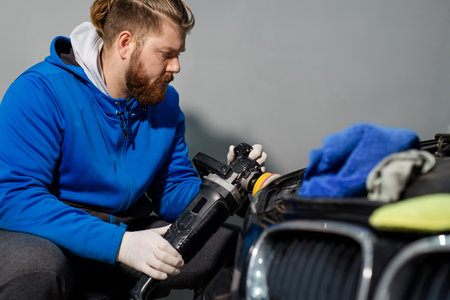 Car headlight cleaning with power buffer machine at service stationの写真素材