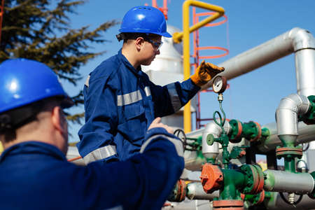 Two engineers working inside oil and gas refineryの写真素材