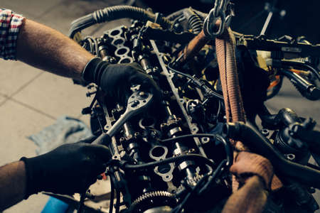 Auto mechanic working and repair on car engine in mechanics garageの写真素材