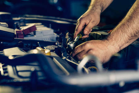 Auto mechanic working and repair on car engine in mechanics garageの写真素材