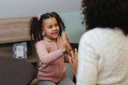 African woman and her little daughter smiling and clapping their handsの写真素材