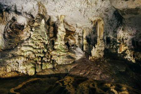 Cave formations of stalactites and stalagmites creating an otherworldly scene in an illuminated cavernの写真素材