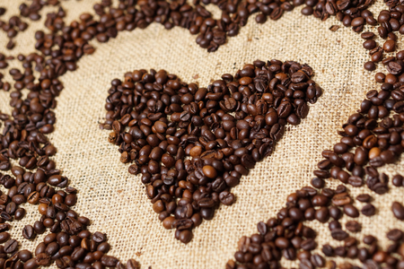 Love heart made of coffee beans on sackclothの写真素材