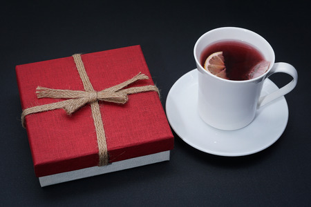 Cup of red tea with lemon slice, present on dark tableの写真素材