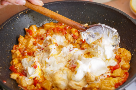Preparation of cutted paprika with chicken meat and cheese in black frying panの写真素材