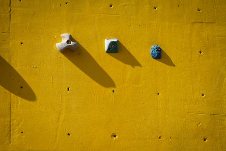 yellow artificial climbing wall with holds outdoorの写真素材
