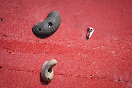 Red artificial climbing wall with holds outdoorの写真素材