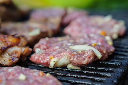 Raw meat on barbecue wire, barbecue preparation, outdoor sceneの写真素材