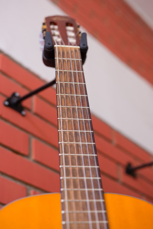 Classic guitar hanged on the brick wallの写真素材