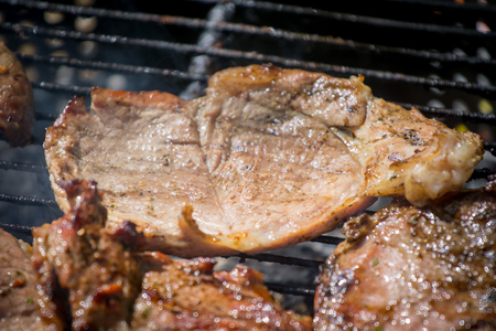Barbecue lunch. Grilled meat chops in a black cast iron pan, close-up.の写真素材