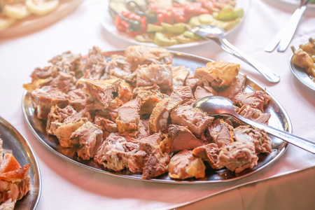 Delicious pieces of pork meat on large plate. Large plate with meat on a wedding.の写真素材