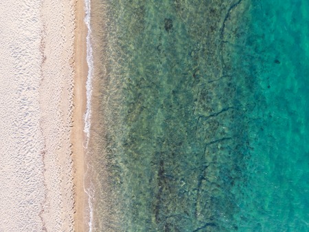 Drone aerial view from above of sandy beach, green and blue sea water.の写真素材