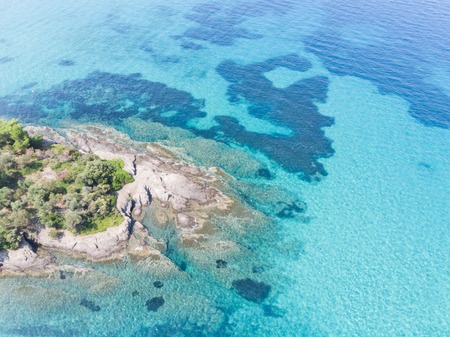Drone aerial view of sea shore on stones and blue water.の写真素材