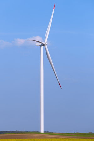 Windmill turbine farm with partly cloudy blue sky in background. Renewable energy wind turbinesの写真素材