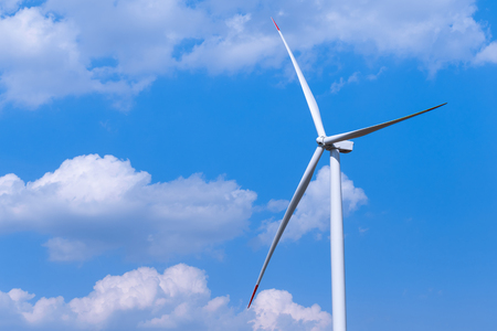Windmill turbine farm with partly cloudy blue sky in background. Renewable energy wind turbinesの写真素材