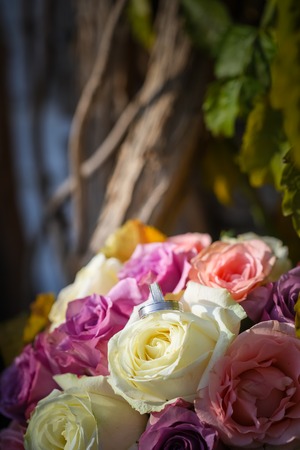 White silver wedding rings on bouquet of pink and white rosesの写真素材