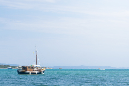 Brown blue wooden boat sails in the sea.の写真素材