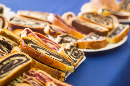Delicious strudel piece with spiral inside on white cardboard plate on blue table.の写真素材