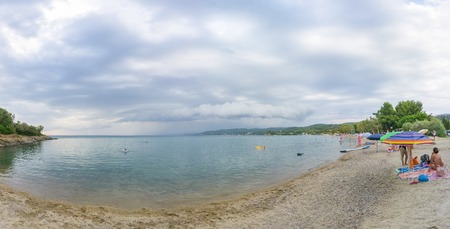 Big rainy clouds above sea water watched from coastの写真素材