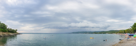 Big rainy clouds above sea water watched from coastの写真素材