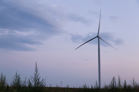 One windmill turbine at blue and purple cloudy sunset skyの写真素材
