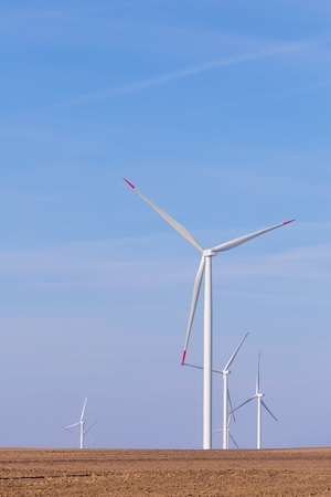 Windmill turbine farm with partly cloudy blue sky in background. Renewable energy wind turbinesの写真素材