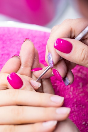 Manicurist remove polish from nails in nail salon.の写真素材