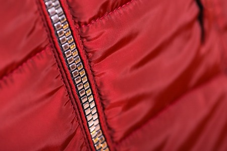 Close up of zipper on red jacket , winter fashion outfit. Jacket isolated on white background.