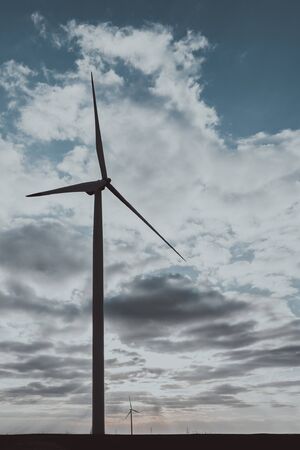 One wind turbine on agricultural ground with cloudy sky in backgroundの写真素材