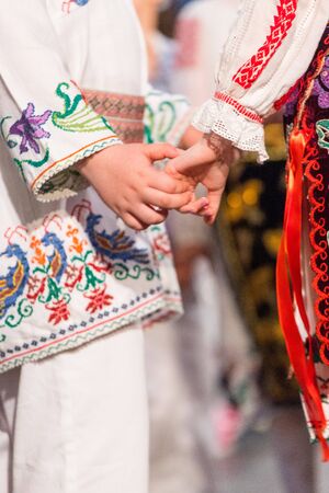 Close up of hands of young Romanian dancers perform a folk dance in traditional folkloric costume. Folklore of Romaniaの写真素材