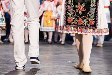 Close up of legs of young Romanian dancers perform a folk dance in traditional folkloric costume. Folklore of Romaniaの写真素材