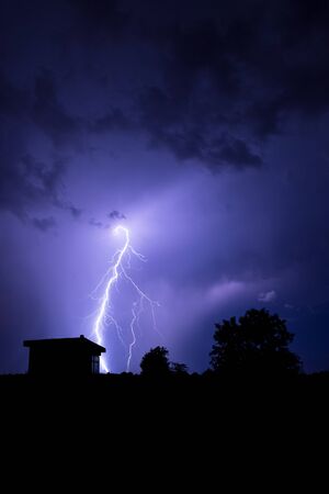 Lightning flashes over the night sky during thunderstorm.の写真素材