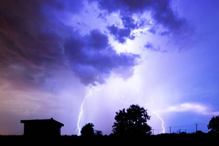 Lightning flashes over the night sky during thunderstorm.の写真素材