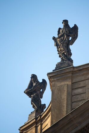 Statues on roof of St. Francis of Assisi church in Prague with blue sky in backgroundの写真素材