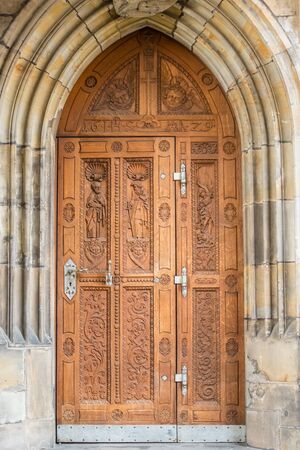 Old wooden door at St. Vitus cathedral in Pragueの写真素材