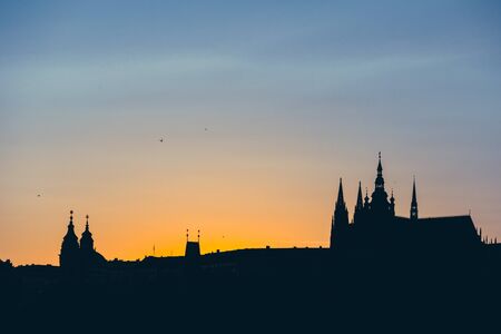 Silhouette at sunset of St. Vitus cathedral against the setting Sun from Prague, Czech Republicの写真素材