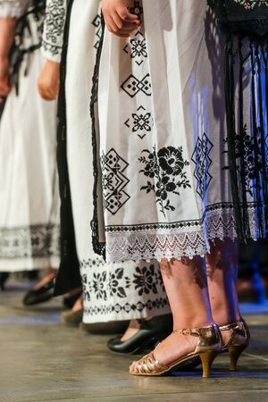 Close up of legs of young Romanian female dancers in traditional folkloric costume. Folklore of...