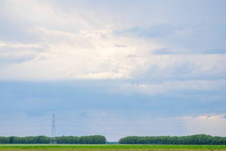 Rainy clouds over trees and agricultural fields