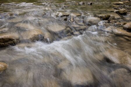 Photo of nature - Long exposure of a mountain stony creek inside in the forest. Small mountain rocky river.の写真素材