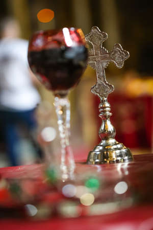 Gold cross next to wine for weddings in the orthodox church. Church wedding attributes.の写真素材