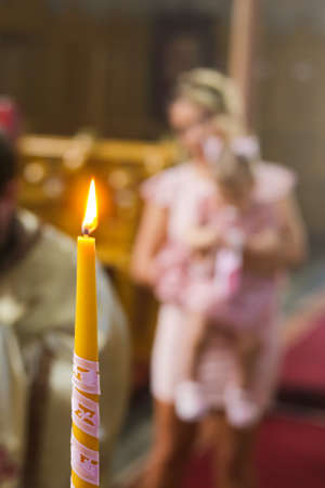Burning candle at Orthodox christening with blurred backgroundの写真素材
