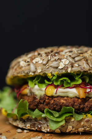 Close up of juicy healthy vegetarian burger on wooden plate