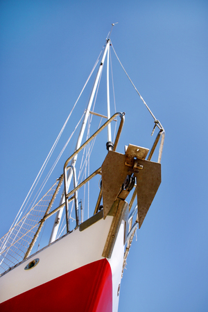 Bow of red and white sailboat, close up, low angle.の写真素材