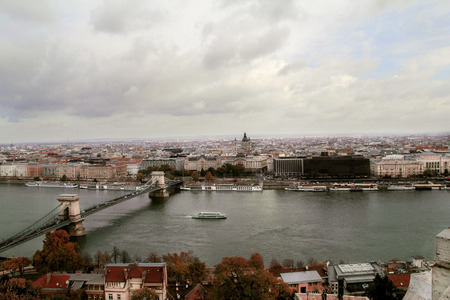 Budapest, Hungary - October 29, 2016: Landmark of Budapest, Chechen Chain Bridge that spans the River Danube between Bud and Pest. Buildings at the banks of the riverのeditorial素材