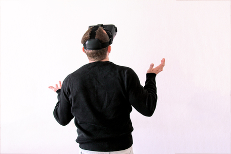 Man using a virtual glasses on white background. Young male business executive using virtual reality headset in officeの写真素材