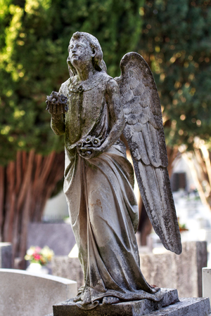 The stone monument statue of angels on the grave with a natural environment in the background. Old city cemetery with tombstones statues. Sculpture Art.の写真素材