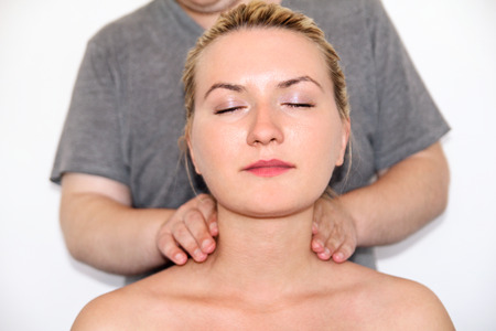 Massage relax studio. Woman having her neck massaged. Massage therapist massaging neck muscles. Body care. Beautiful young woman relaxing with hand massage at beauty body spa.の写真素材