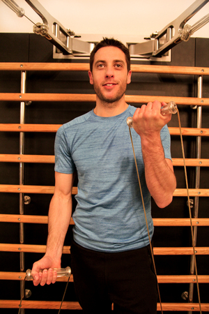 Man working fitness sport exercise for biceps on kinesis technology machine straps in the gym....