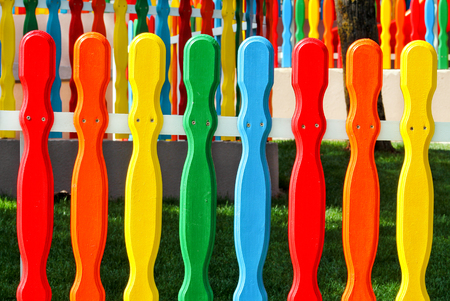 Colorful wooden decorative fence in the park. Colored wooden plank panel background texture. Art wooden background. Creative colorful wallpaper.の写真素材